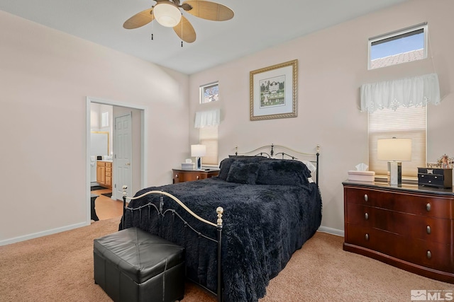 carpeted bedroom with ensuite bath and ceiling fan