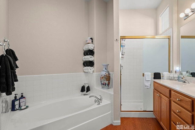 bathroom featuring wood-type flooring, independent shower and bath, and vanity