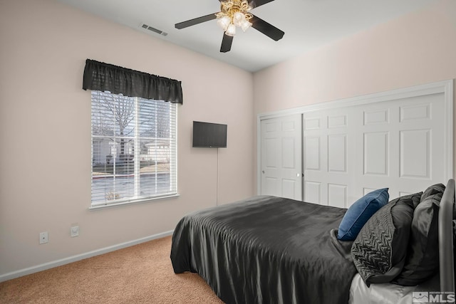 carpeted bedroom featuring ceiling fan and a closet