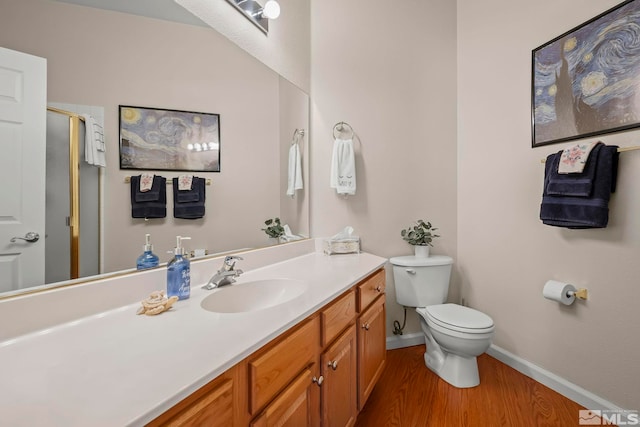 bathroom with hardwood / wood-style floors, an enclosed shower, vanity, and toilet