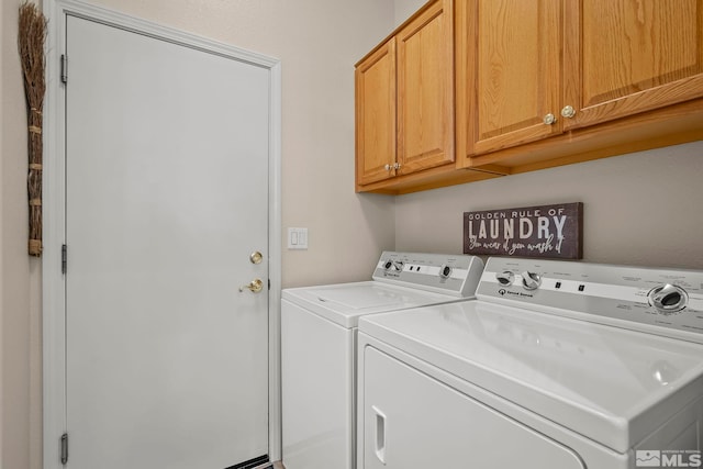 laundry room featuring separate washer and dryer and cabinets