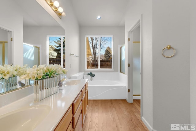 bathroom featuring independent shower and bath, hardwood / wood-style floors, and vanity