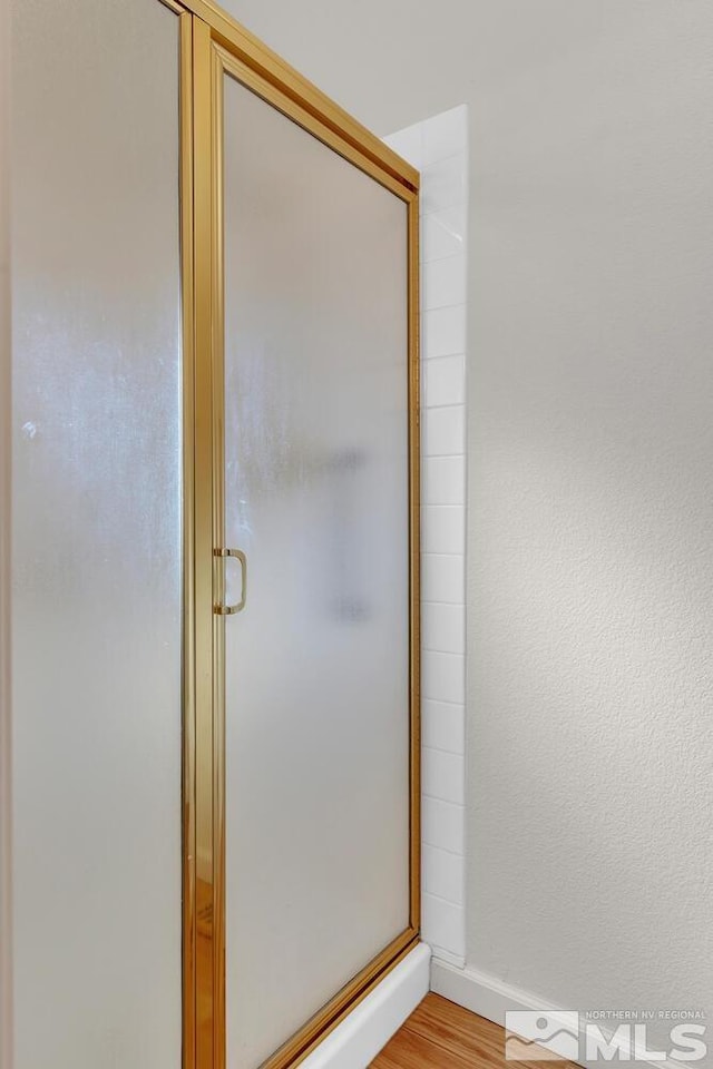 bathroom featuring hardwood / wood-style flooring and walk in shower