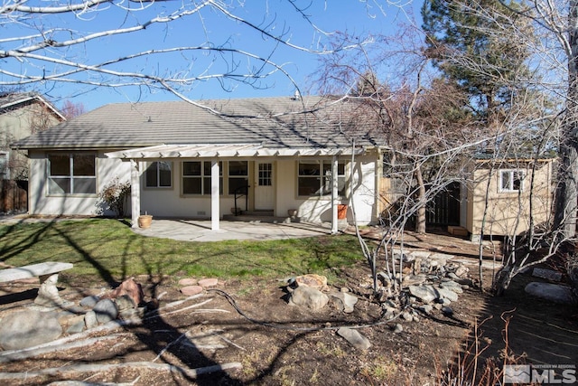 rear view of house with a lawn and a patio area