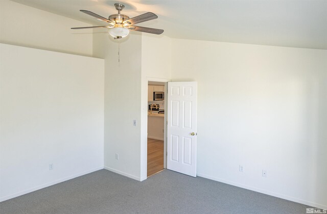 empty room with dark carpet and ceiling fan