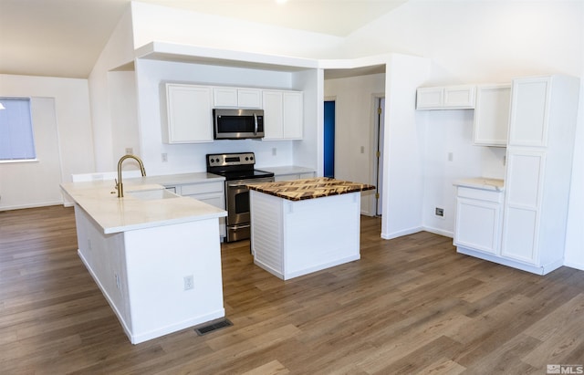 kitchen featuring stainless steel appliances, sink, white cabinets, a center island, and light hardwood / wood-style flooring