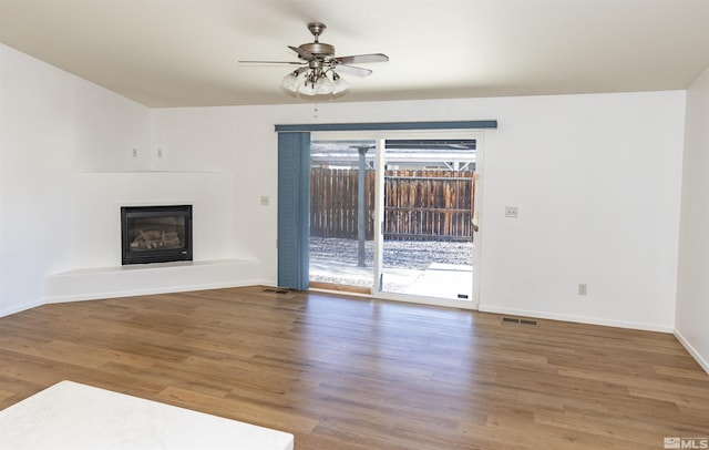 unfurnished living room featuring ceiling fan and hardwood / wood-style flooring