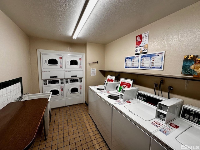 laundry area featuring stacked washer and dryer, a textured ceiling, separate washer and dryer, and dark tile patterned flooring