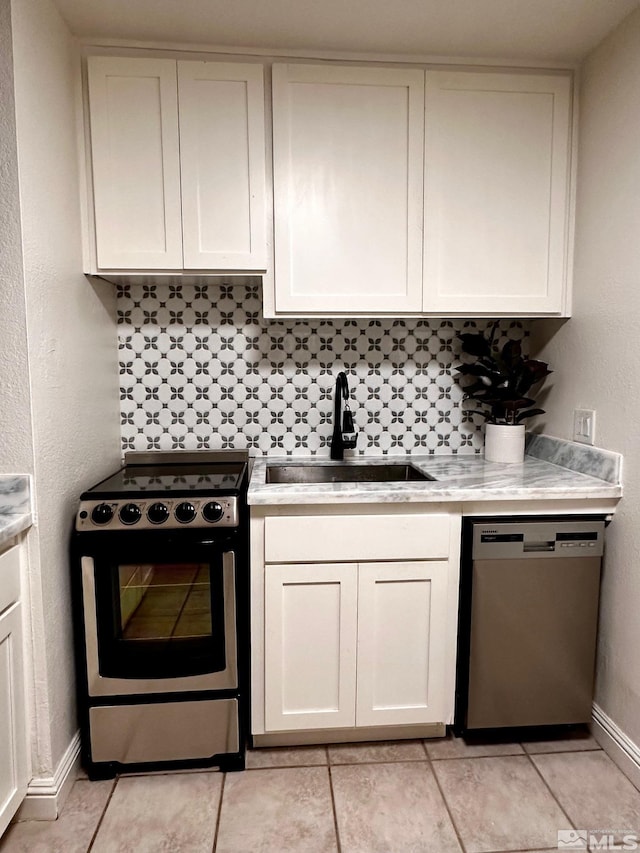 kitchen featuring sink, white cabinets, light tile patterned flooring, and appliances with stainless steel finishes