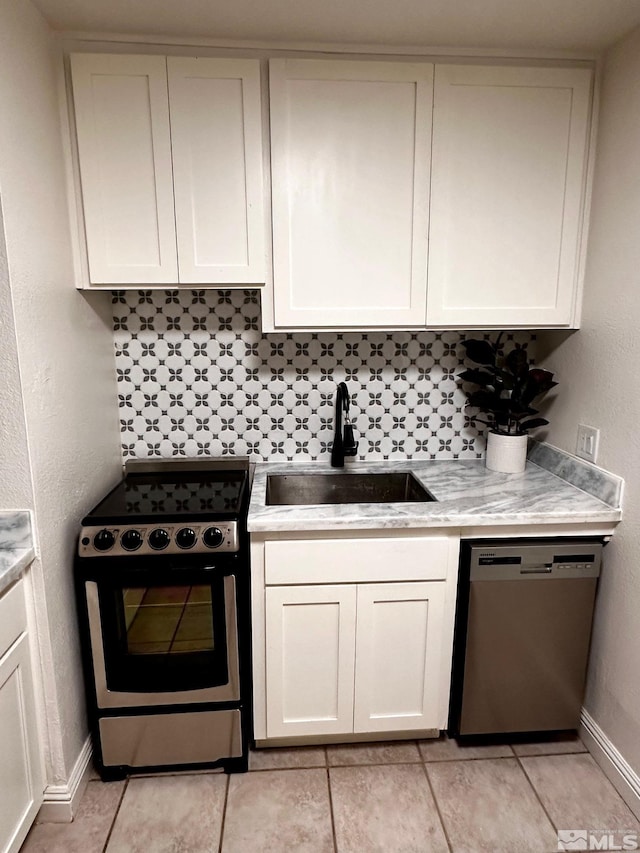 kitchen with dishwasher, light tile patterned floors, electric range, white cabinetry, and sink