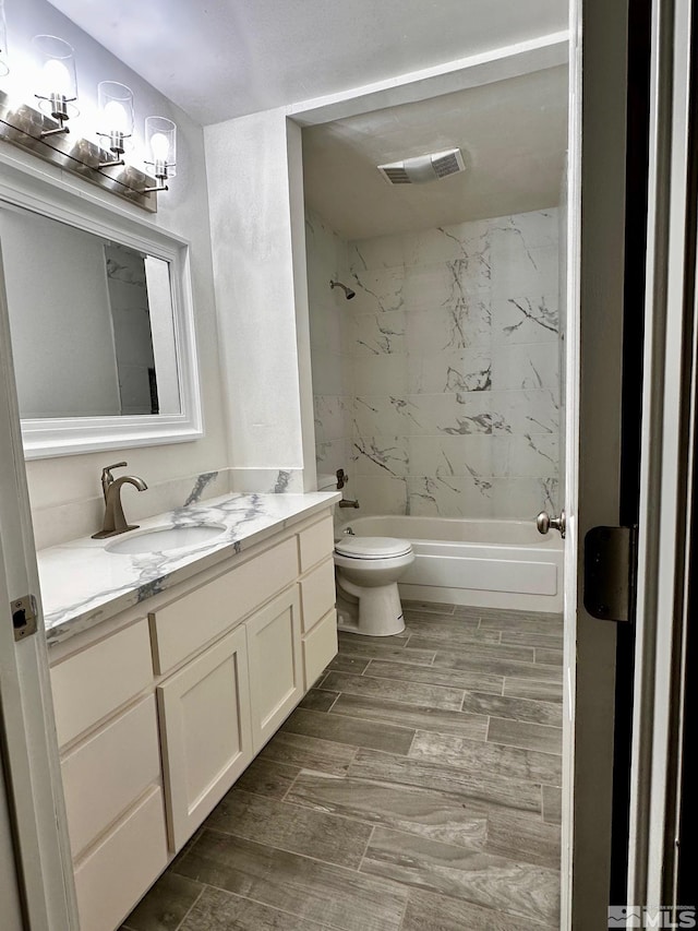 full bathroom featuring toilet, vanity, and tiled shower / bath combo