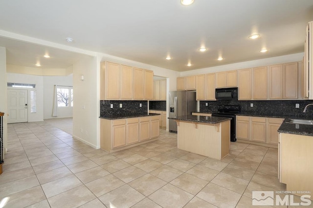 kitchen with black appliances, dark stone counters, sink, and a kitchen island