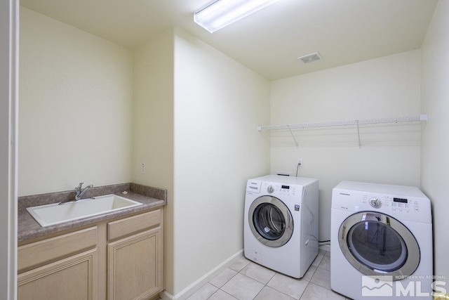 laundry room with sink, light tile patterned flooring, and independent washer and dryer