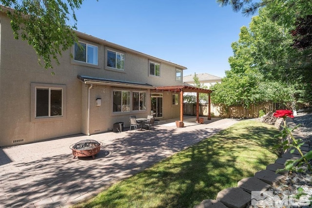 rear view of house with a patio and an outdoor fire pit