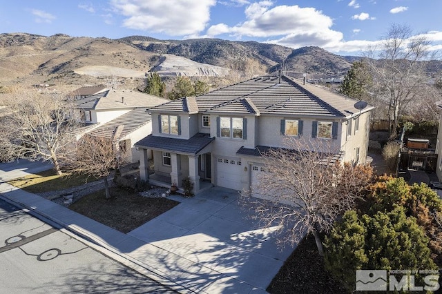 front of property with a garage and a mountain view