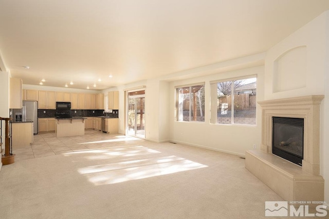 unfurnished living room with light colored carpet