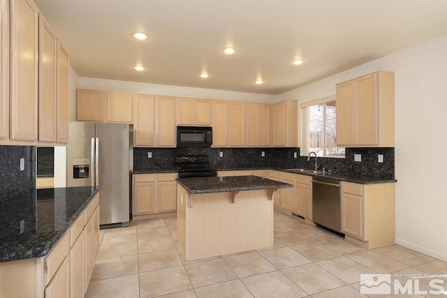 kitchen featuring black appliances, dark stone counters, a center island, and sink