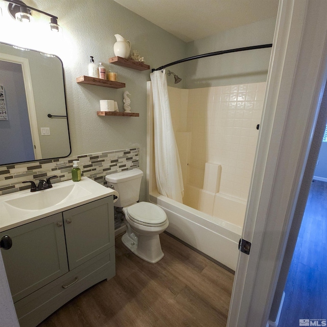 full bathroom with toilet, decorative backsplash, shower / tub combo, wood-type flooring, and vanity