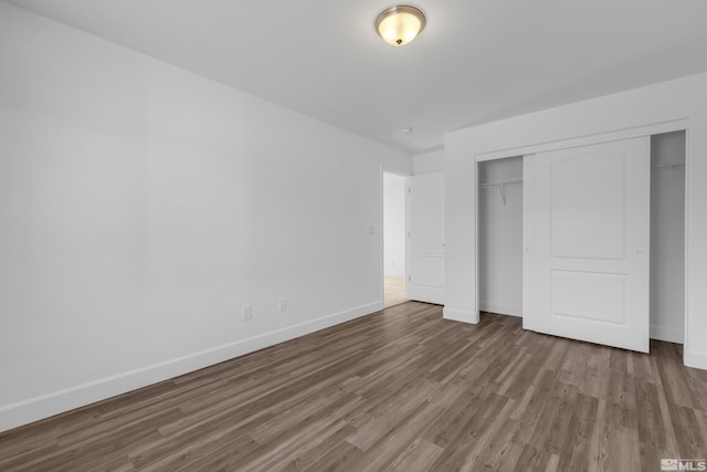 unfurnished bedroom with a closet and wood-type flooring