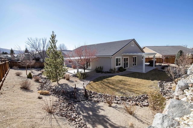 rear view of property featuring a lawn, a pergola, and a patio area