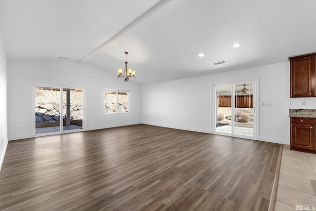 unfurnished living room with light wood-type flooring, lofted ceiling with beams, and a chandelier