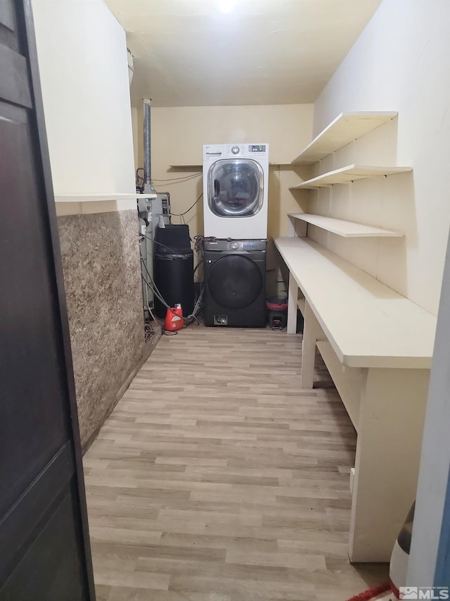 laundry room featuring light hardwood / wood-style floors and stacked washer / dryer