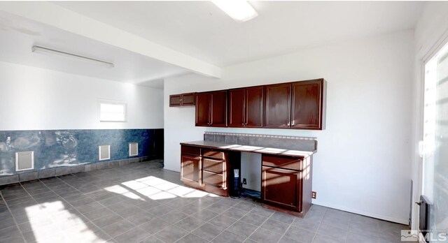 kitchen featuring light tile patterned floors and beam ceiling