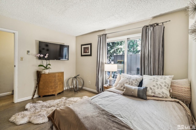 bedroom with a textured ceiling and hardwood / wood-style flooring