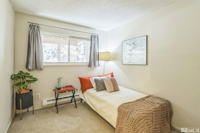 bedroom featuring a baseboard heating unit, a textured ceiling, and light carpet