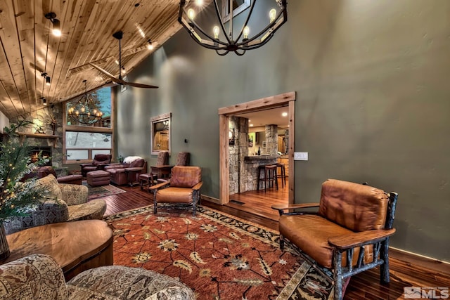 living room with wooden ceiling, a fireplace, hardwood / wood-style flooring, ceiling fan with notable chandelier, and high vaulted ceiling