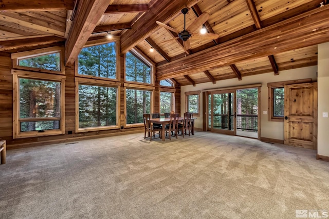 unfurnished sunroom with ceiling fan, lofted ceiling with beams, wood ceiling, and plenty of natural light