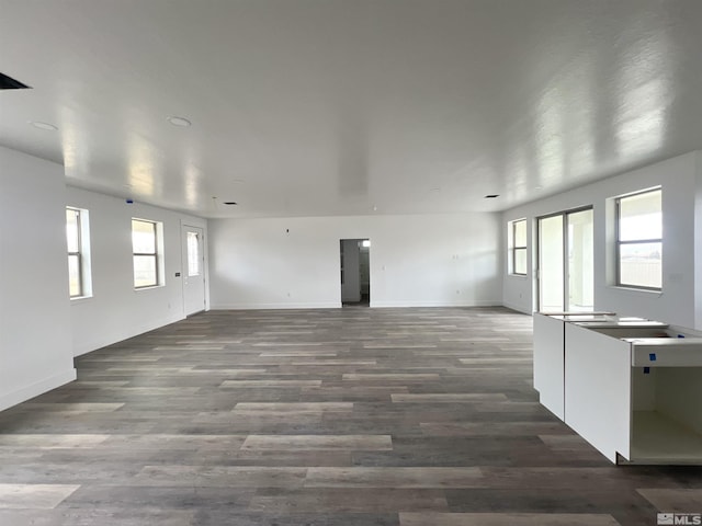 unfurnished living room featuring dark hardwood / wood-style floors and plenty of natural light