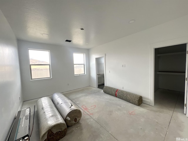 unfurnished bedroom featuring a walk in closet