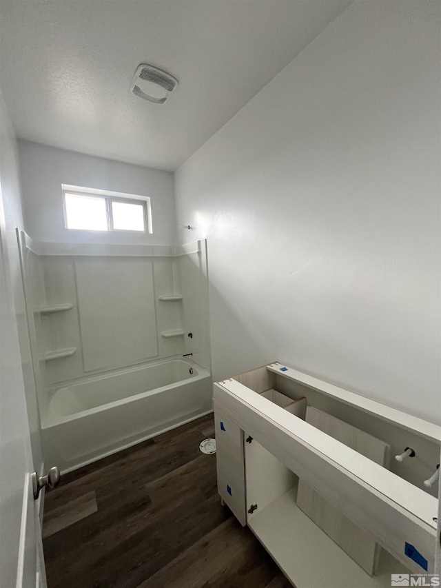 bathroom featuring bathing tub / shower combination and hardwood / wood-style floors