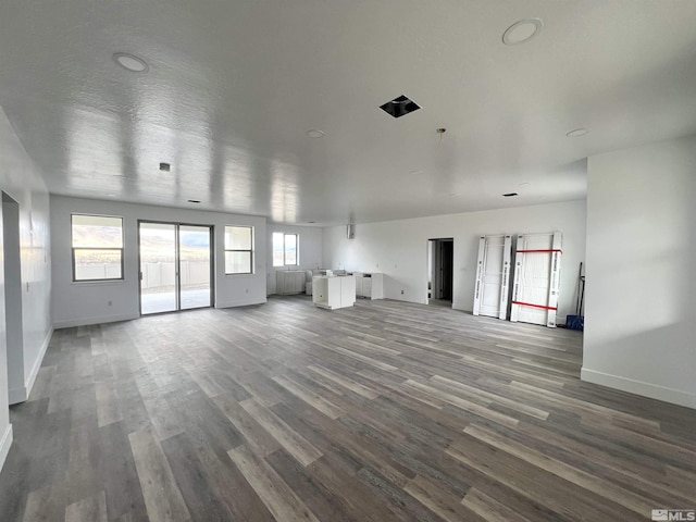 unfurnished living room featuring a textured ceiling and wood-type flooring