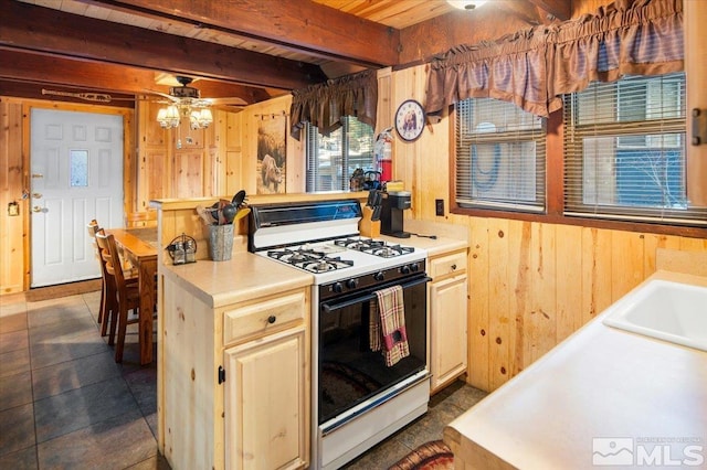 kitchen with beamed ceiling, white range with gas cooktop, ceiling fan, wood walls, and wood ceiling