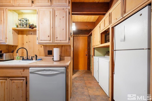 kitchen with white appliances, washer and dryer, beamed ceiling, light brown cabinets, and sink