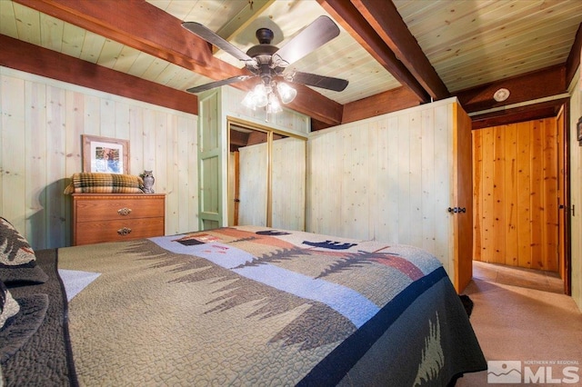 carpeted bedroom featuring wooden ceiling, a closet, wood walls, ceiling fan, and beam ceiling