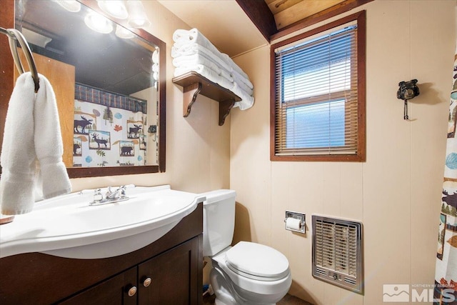 bathroom with toilet, vanity, heating unit, and walk in shower