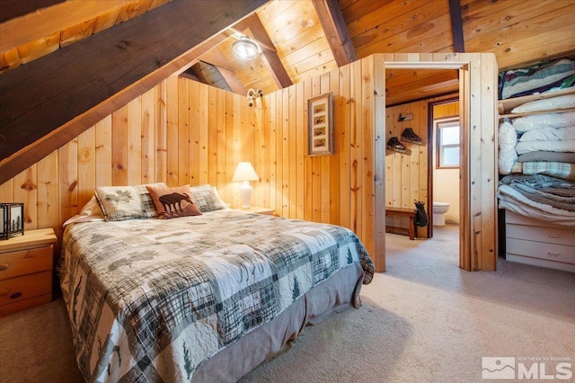 carpeted bedroom with wood ceiling, connected bathroom, vaulted ceiling with beams, and wood walls