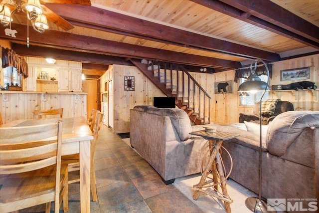 living room with wood walls, wood ceiling, and beamed ceiling