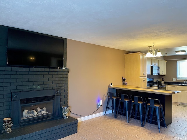 kitchen with decorative light fixtures, a kitchen bar, kitchen peninsula, range, and a chandelier