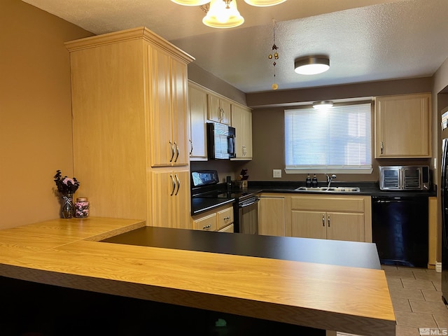 kitchen featuring a textured ceiling, light brown cabinetry, light tile patterned floors, black appliances, and sink