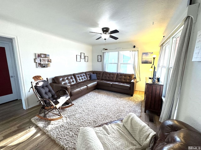 living room featuring a textured ceiling, ceiling fan, and hardwood / wood-style flooring