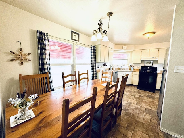 dining space featuring sink and a chandelier