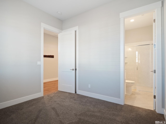 unfurnished bedroom featuring connected bathroom and carpet flooring