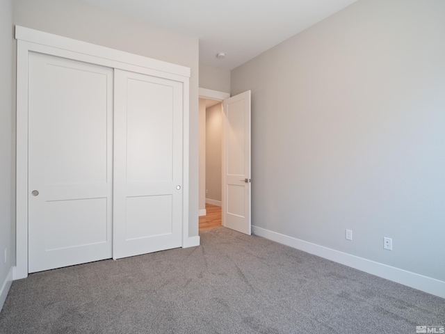 unfurnished bedroom featuring carpet flooring and a closet