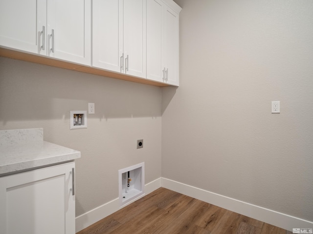 laundry area with electric dryer hookup, hardwood / wood-style floors, cabinets, and washer hookup