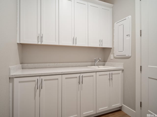 laundry area with sink, hardwood / wood-style flooring, and electric panel