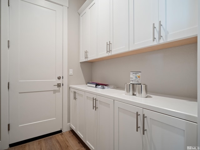 clothes washing area featuring light hardwood / wood-style floors